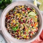Tex-Mex Rice and Bean Salad with basmati rice, black beans, kidney beans, corn, red bell pepper, and green onions in a wooden bowl.