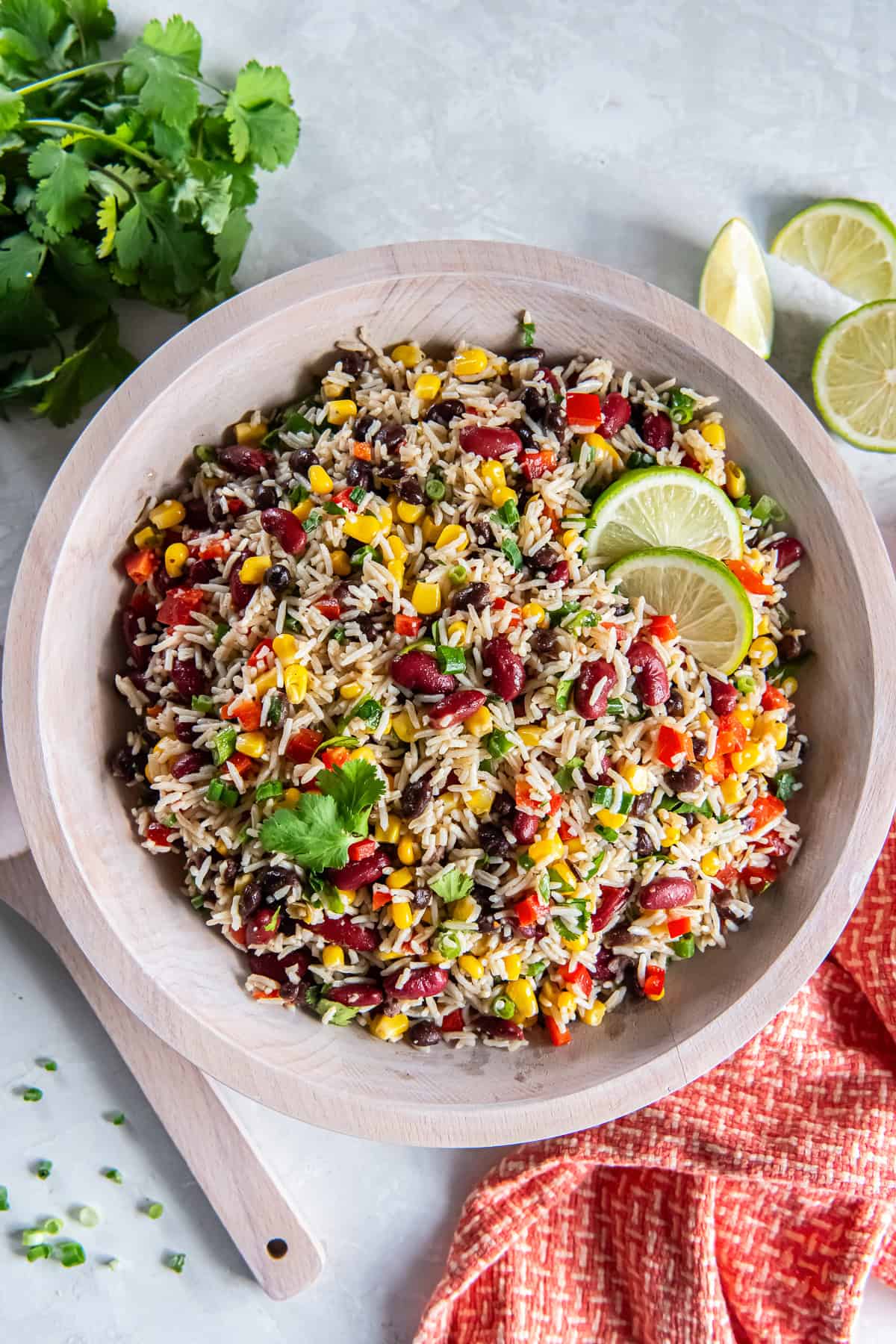 Tex-Mex Rice and Bean Salad with basmati rice, black beans, kidney beans, corn, red bell pepper, and green onions in a wooden bowl.