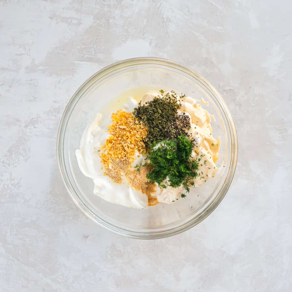 Make vegetable dip by adding sour cream, mayonnaise, herbs, and seasonings to a bowl.