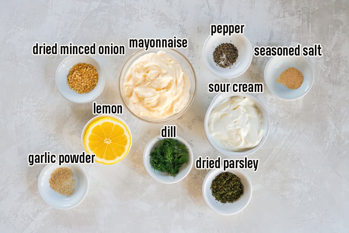 Contains ingredients for an easy vegetable dip recipe: sour cream, mayonnaise, dried herbs, garlic powder, seasoned salt, black pepper, and fresh lemon.
