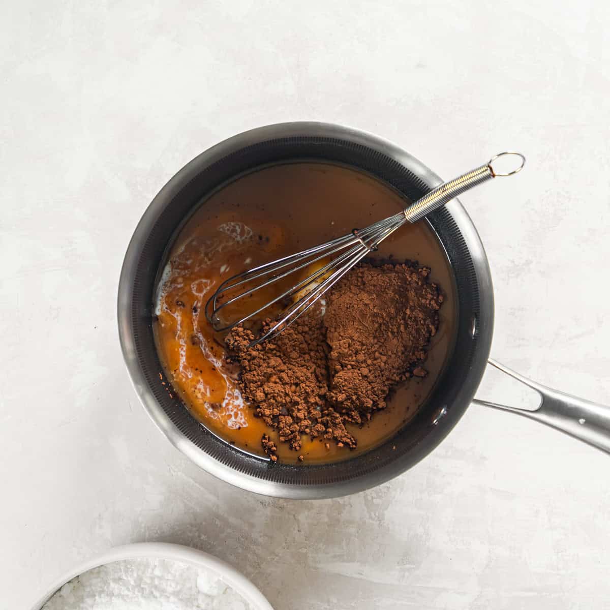 Cocoa powder, milk, and vanilla added to melted butter and peanut butter for the icing