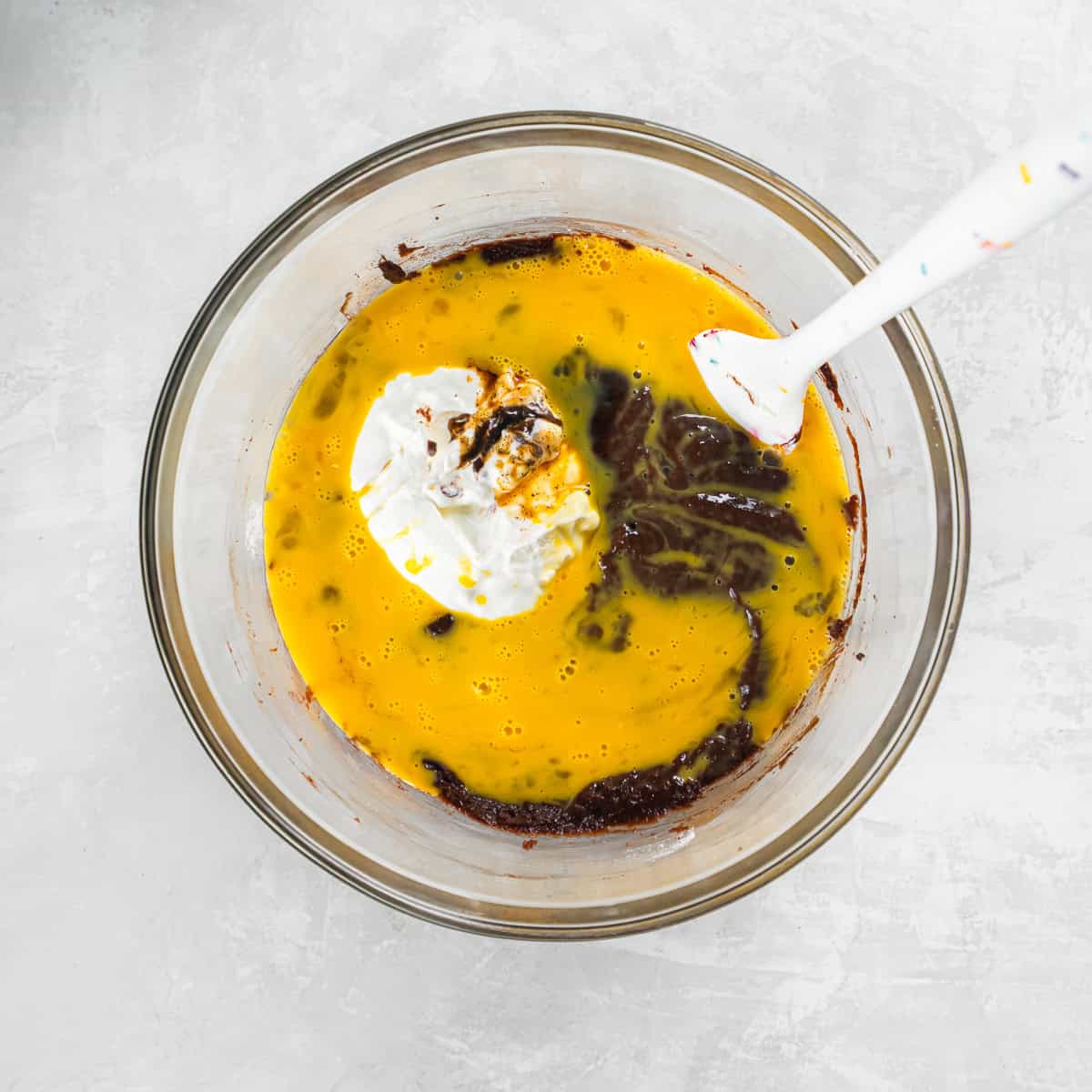 Eggs, sour cream, and vanilla added to the cake batter before mixing.