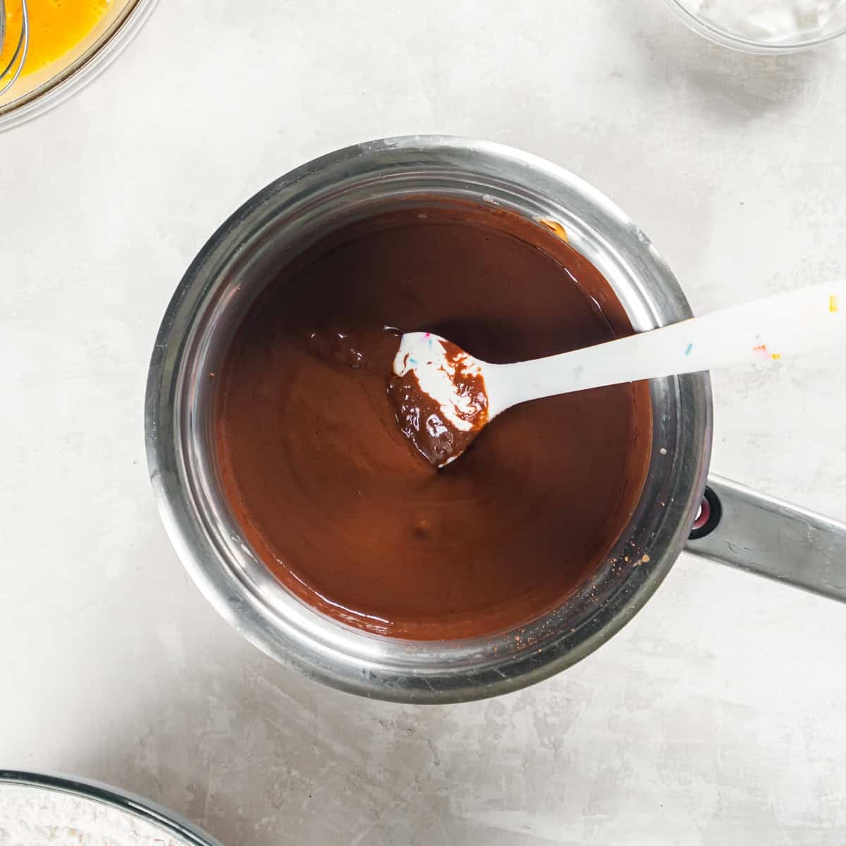 Smooth chocolate and peanut butter mixture in a saucepan for Chocolate Peanut Butter Sheet Cake.