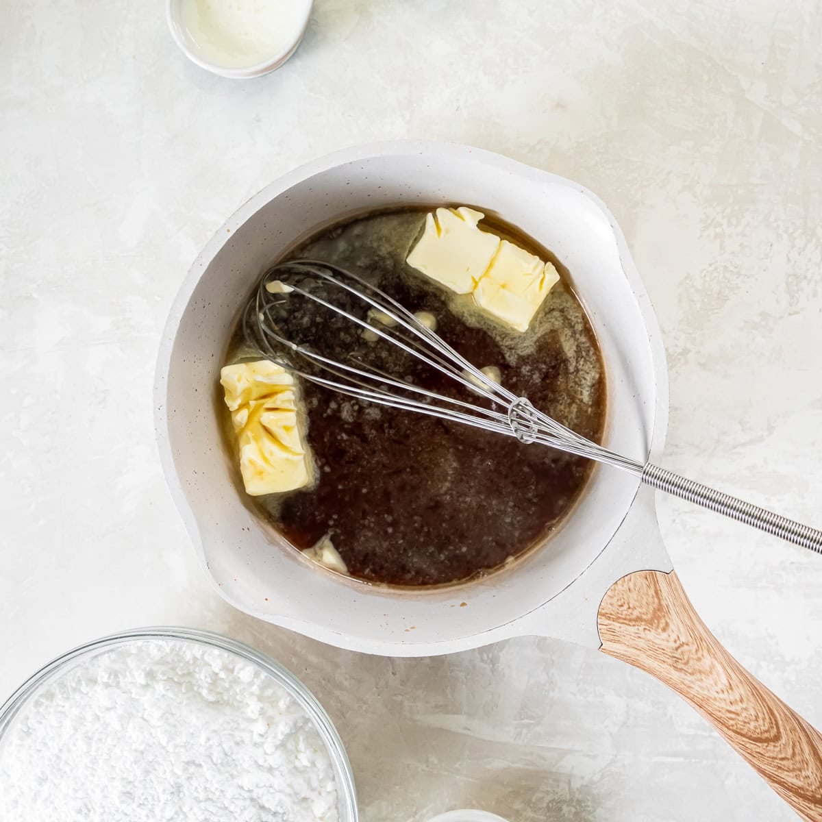 Reduced Coca-Cola and butter combined in a saucepan to begin making the chocolate glaze.