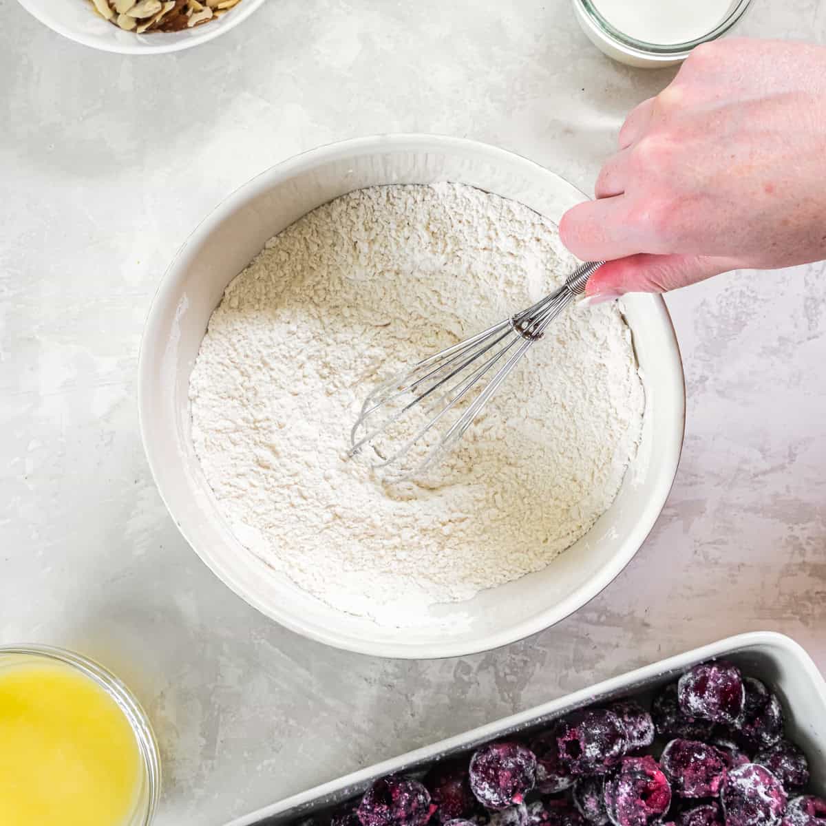 Flour, sugar, baking powder, and salt whisked together for cobbler dough.
