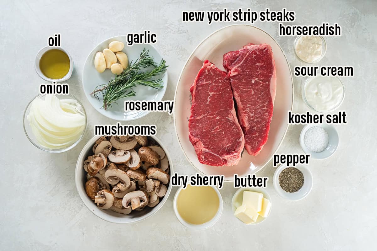 Alt text:
Ingredients for a New York Strip Steak Recipe with mushrooms and onions, including New York strip steaks, mushrooms, onion, garlic, rosemary, butter, dry sherry, sour cream, horseradish, olive oil, kosher salt, and black pepper.