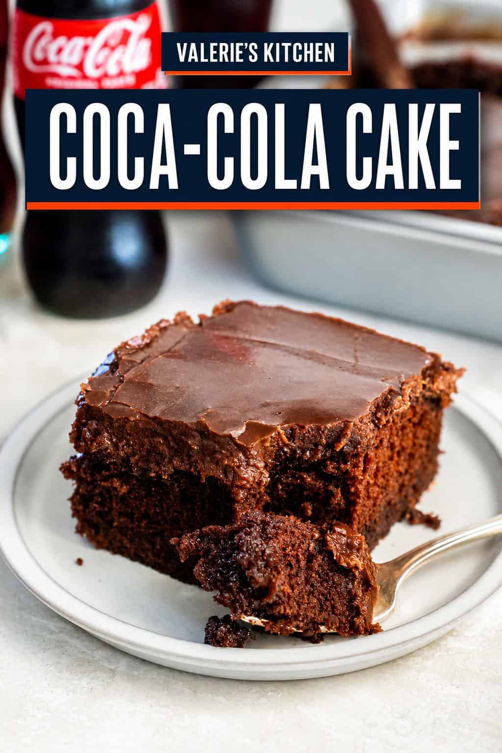 A slice of Coca-Cola chocolate cake on a small plate with a bite on a fork in the foreground. The cake is topped with a glossy chocolate frosting, with a glass Coca-Cola bottle and the remaining cake in the background with title text overlay.