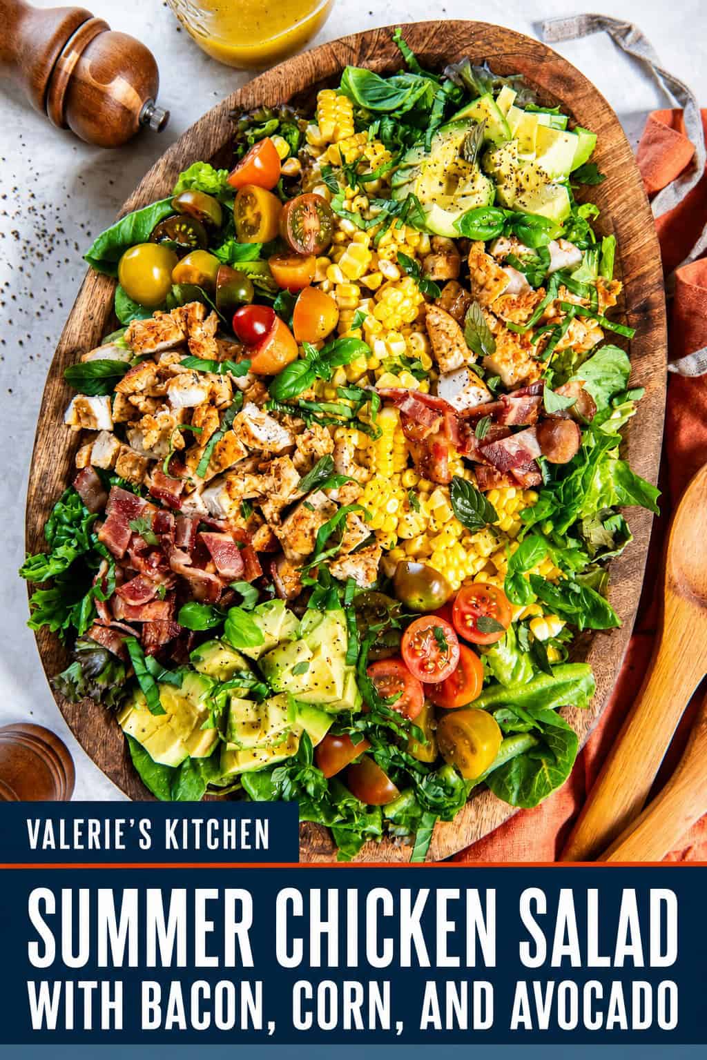 Summer Chicken Salad with bacon, corn, avocado, tomatoes, and Cajun chicken on a bed of fresh greens, served on a wooden platter with apple cider vinaigrette with bold title text overlay.