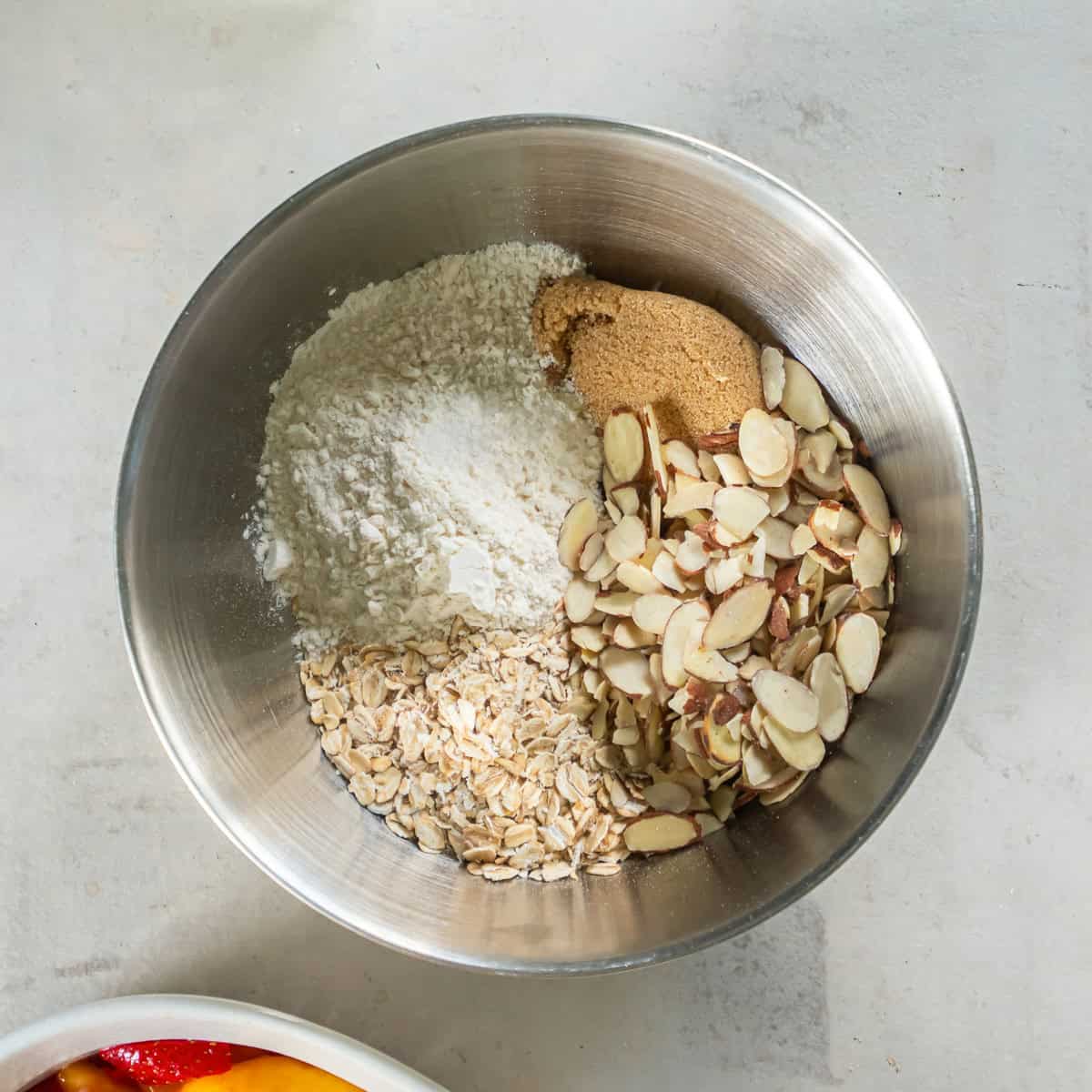 Flour, oats, sliced almonds, brown sugar, and salt in a mixing bowl for the crisp topping.