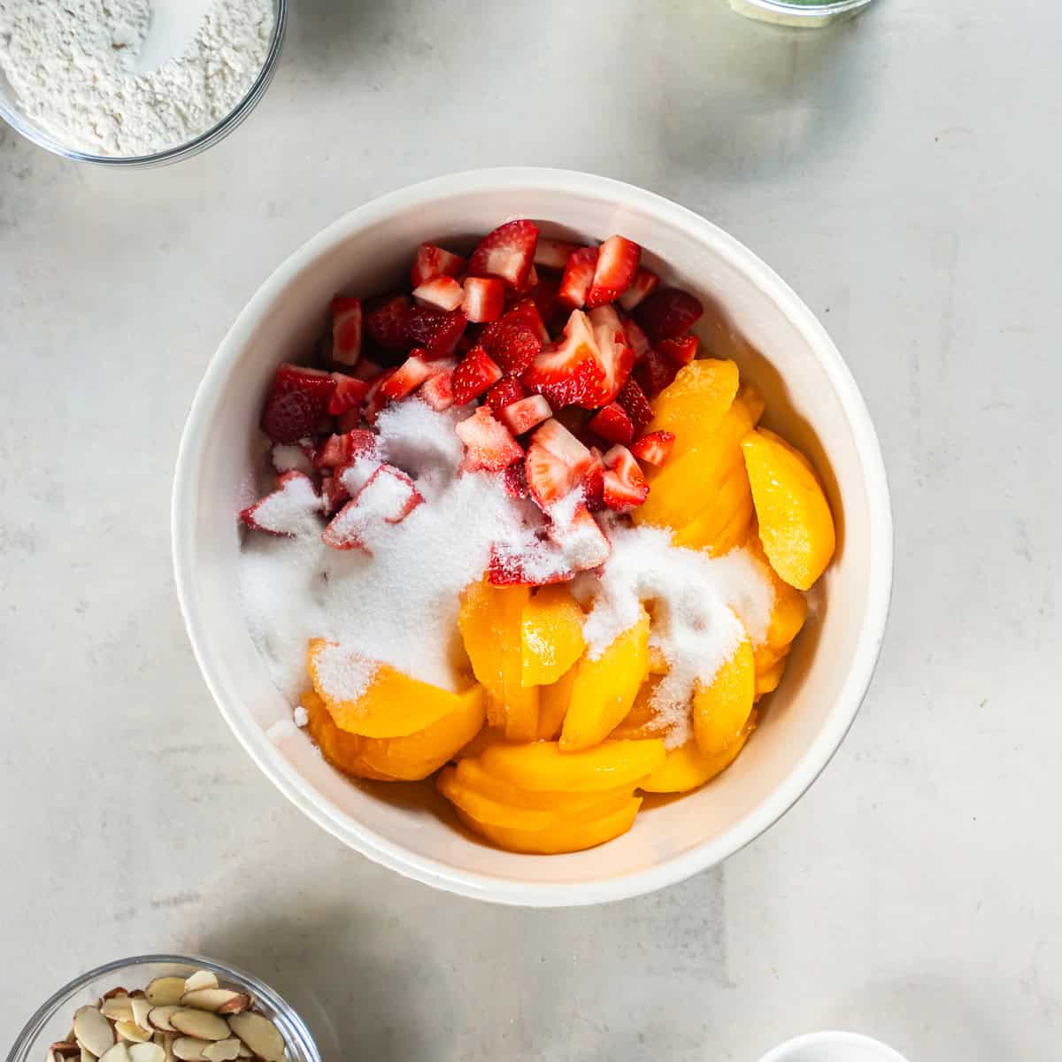 Sliced peaches, chopped strawberries, and sugar added to the lemon juice mixture.