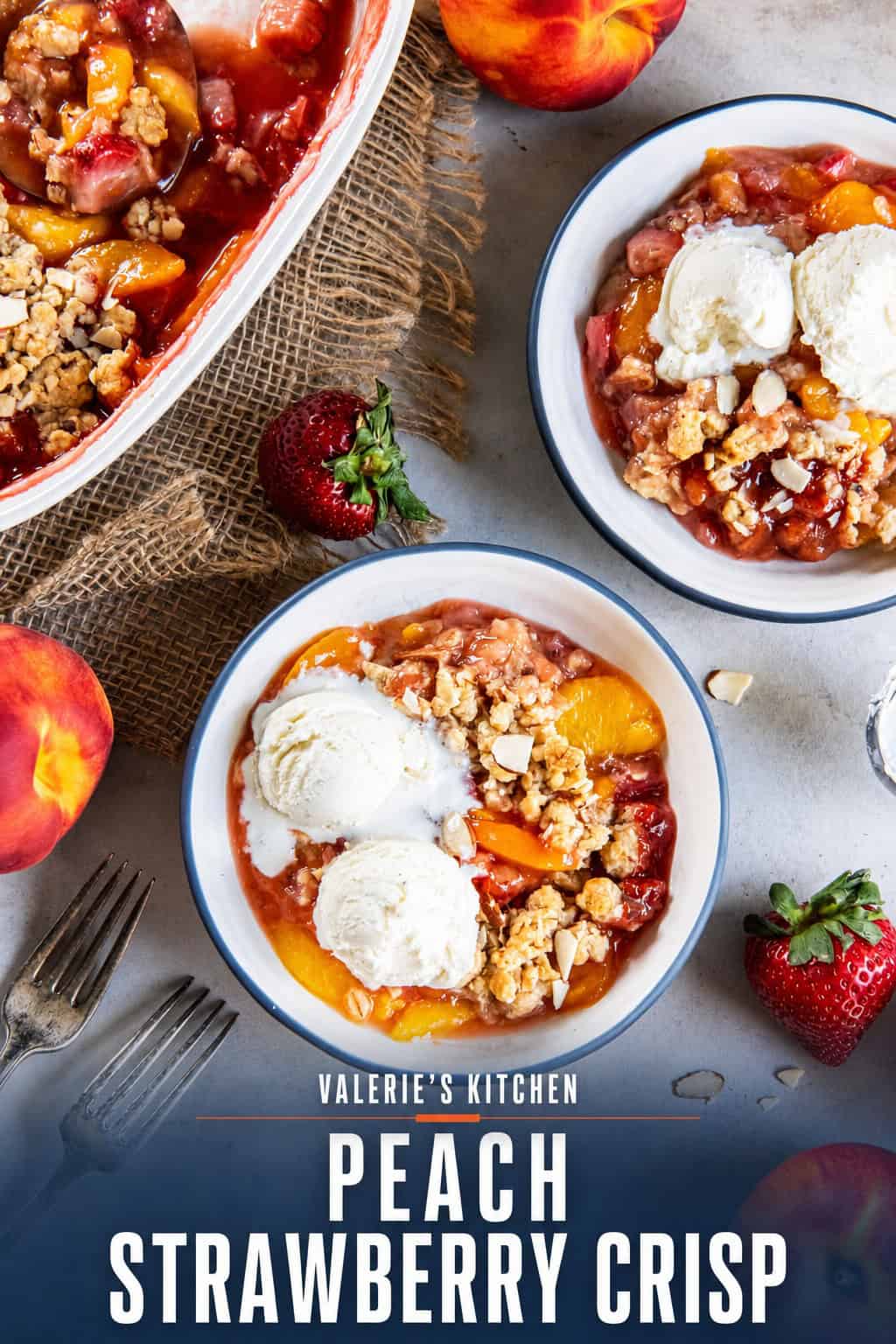 Peach Strawberry Crisp with vanilla ice cream served in bowls next to the baking dish and fresh peaches and strawberries with bold text overlay.