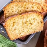 Sliced pineapple zucchini bread with a soft, moist crumb and bits of fresh zucchini throughout.