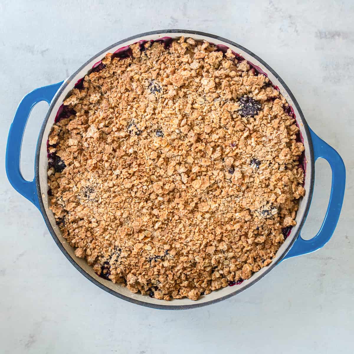 Freshly baked Apple Berry Crisp with a golden brown oat topping and berry filling bubbling around the edges.