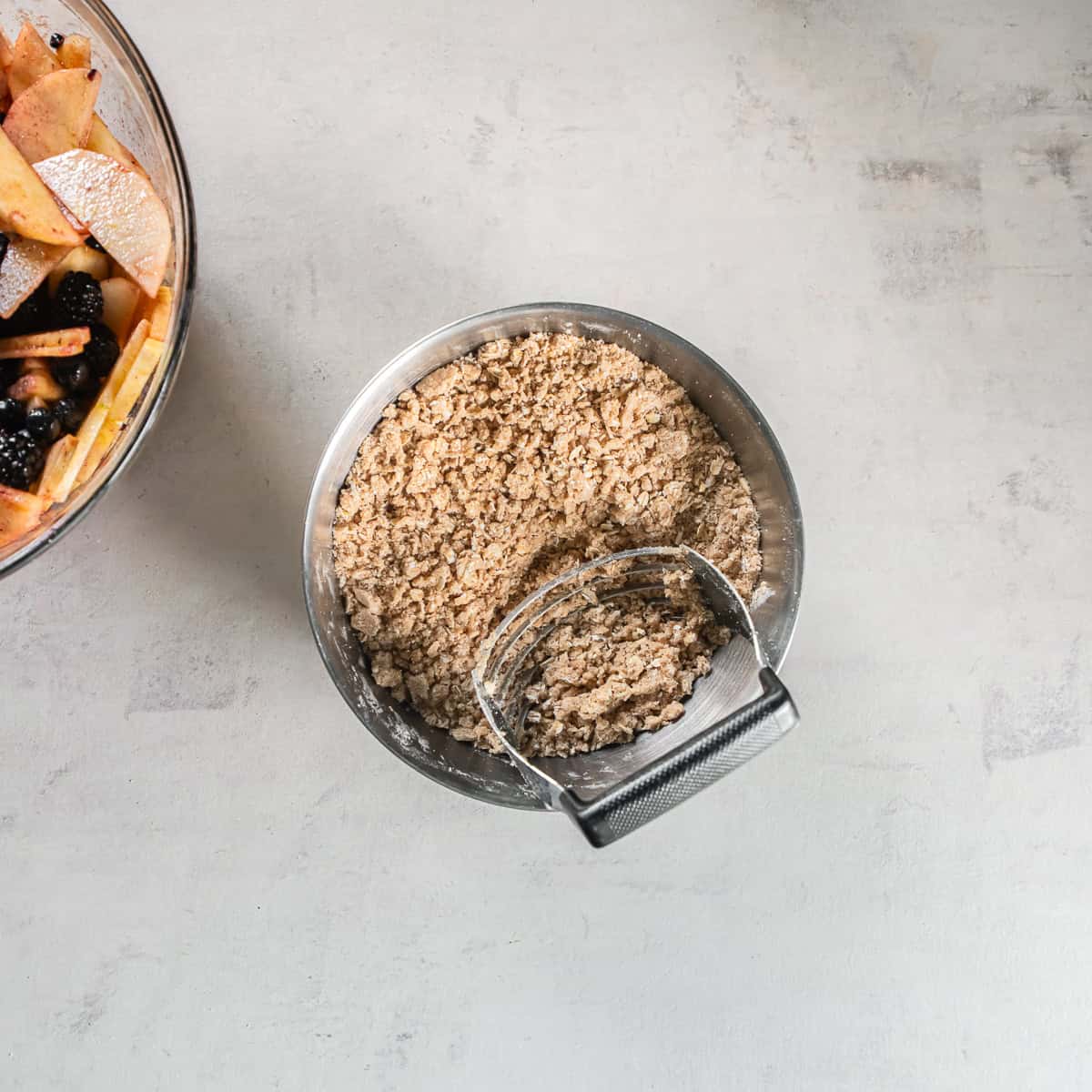 Crumbly oat crisp topping with small pieces of butter mixed throughout in a metal bowl.