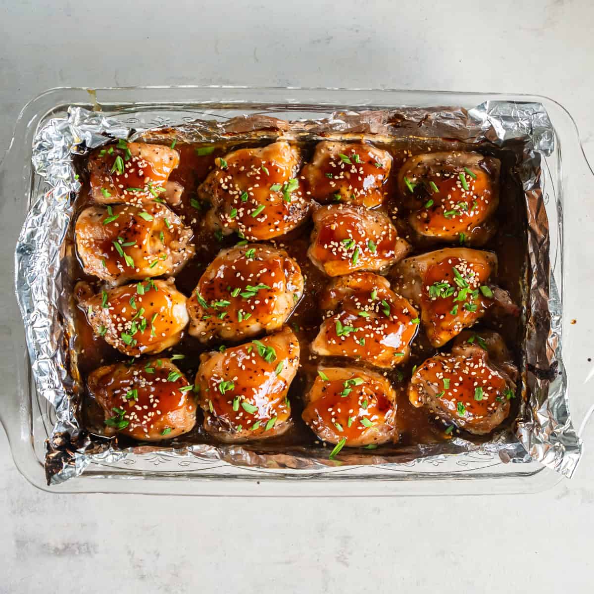 Baked Teriyaki Chicken garnished with sesame seeds and sliced green onions.