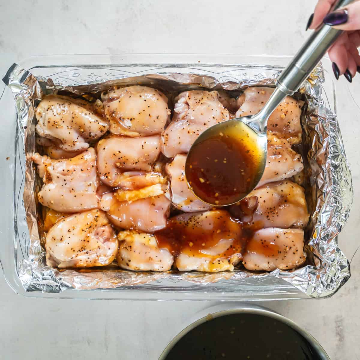 Reserved teriyaki sauce spooned over chicken thighs during baking.
