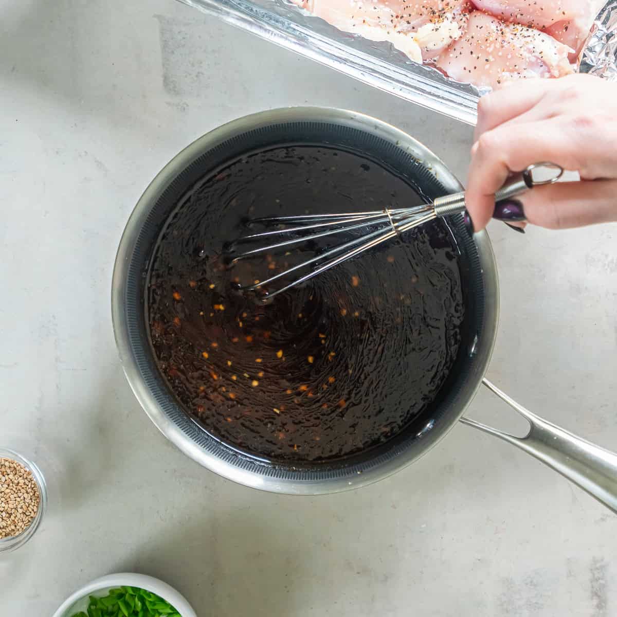 Thickened homemade teriyaki sauce being whisked in a saucepan.