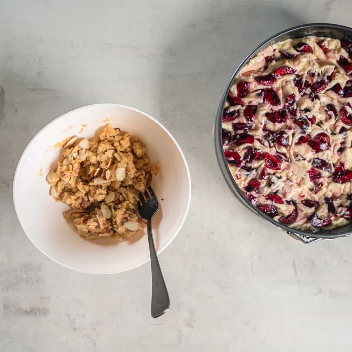 Gently swirling the cherries into the batter before adding the crumb topping.