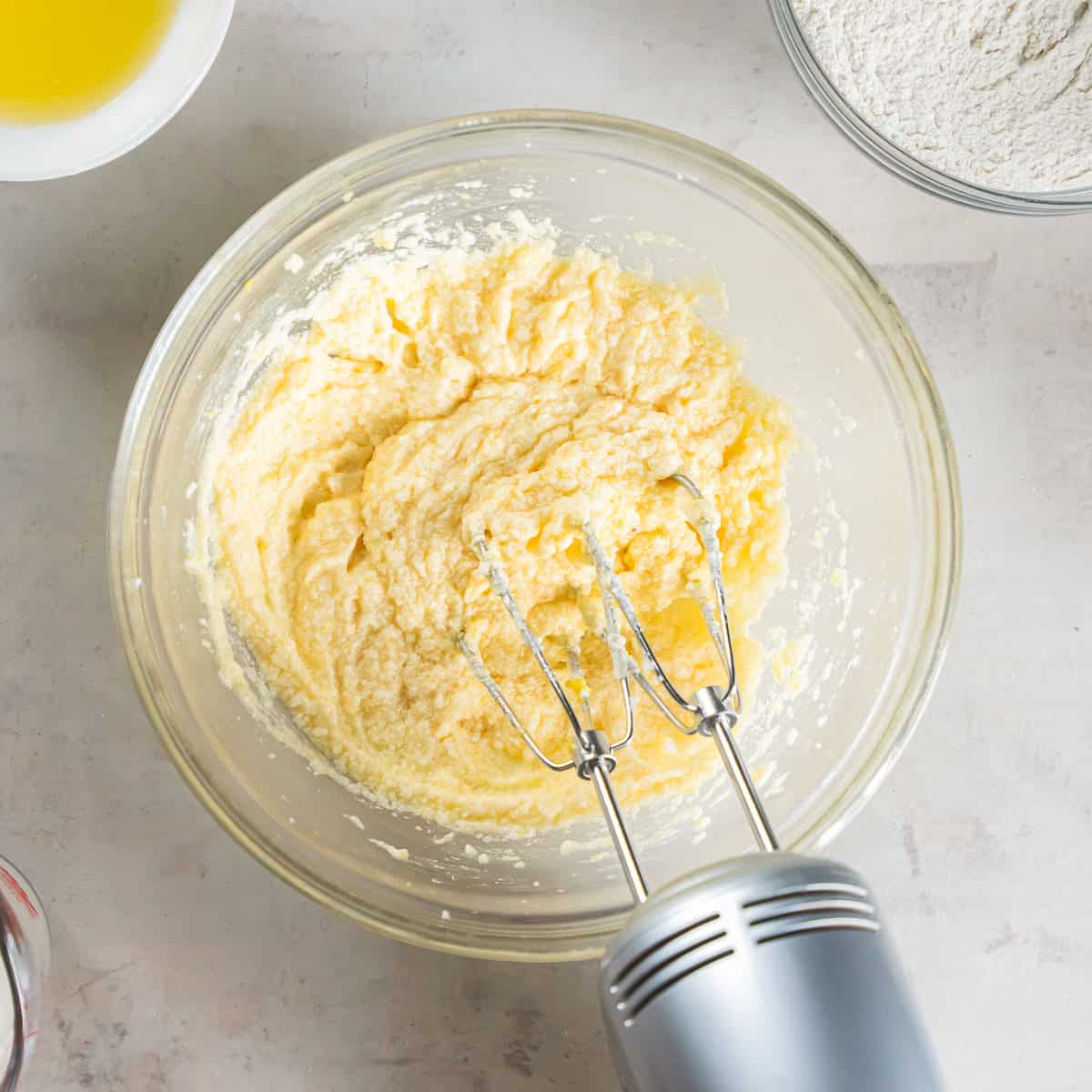Adding the egg, lemon juice, lemon zest, vanilla extract, and almond extract to the butter mixture.