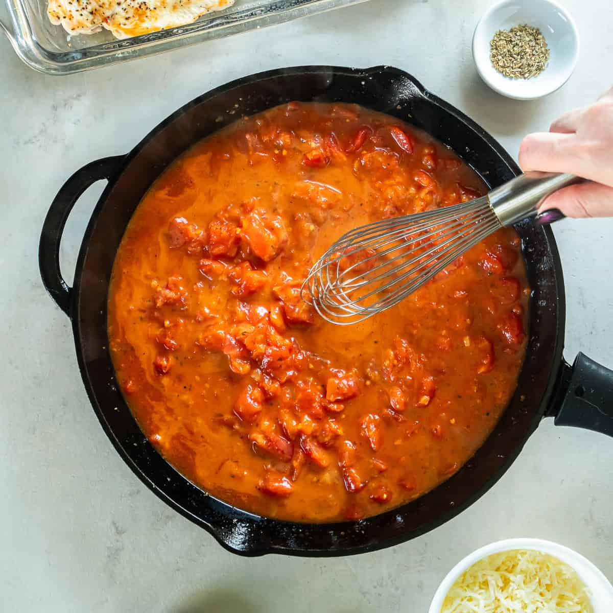 Whisking cornstarch into diced tomatoes to create a thickened sauce.