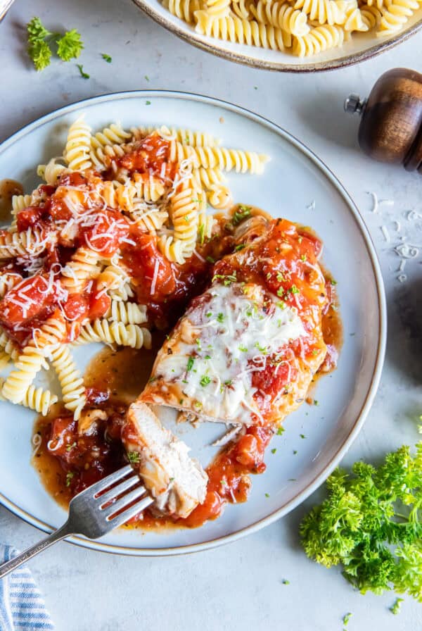 Italian baked chicken served with rotini pasta topped with chunky tomato sauce and grated Parmesan.