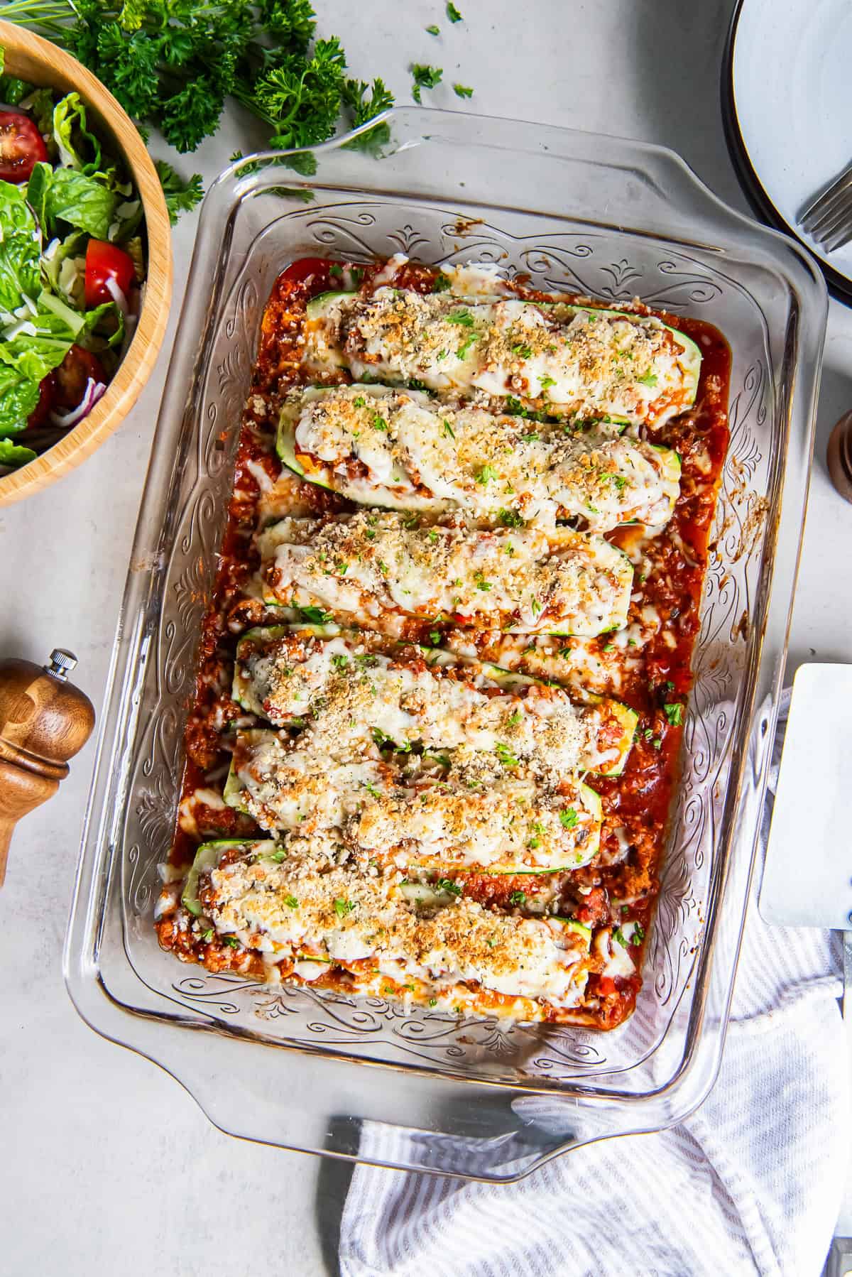Italian Stuffed Zucchini Boats topped with melted cheese and golden breadcrumbs in a baking dish.