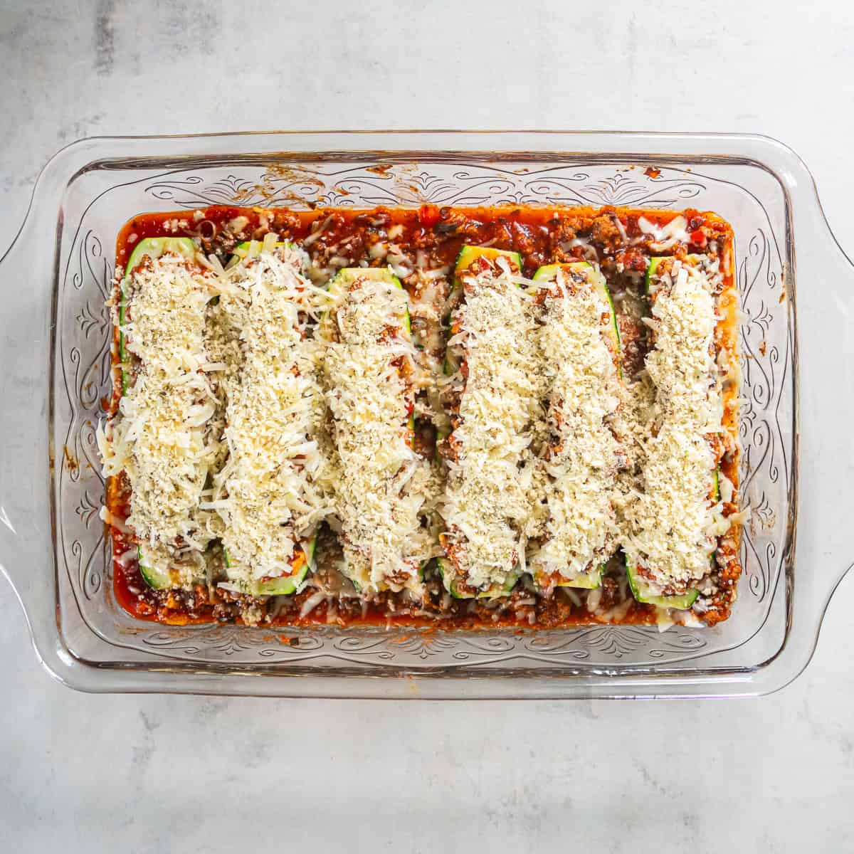 Stuffed zucchini boats topped with mozzarella, Parmesan, and panko bread crumbs before broiling.