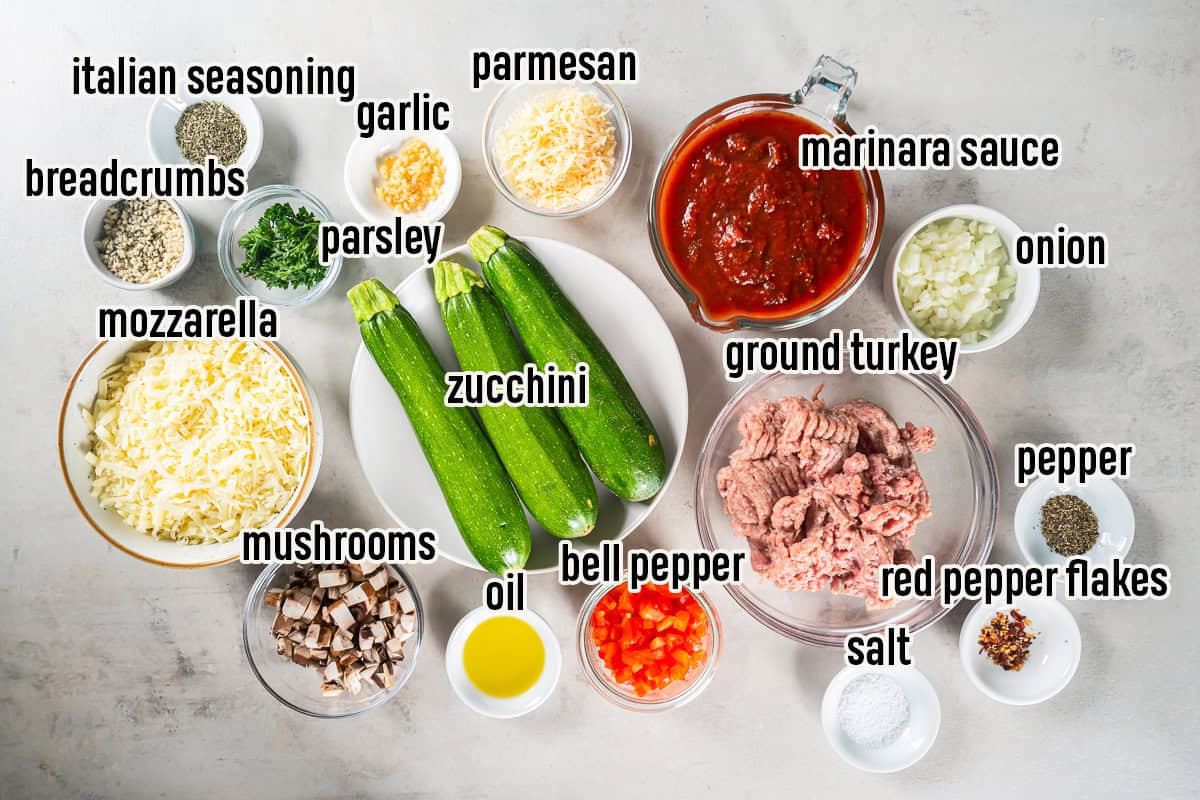 Italian Stuffed Zucchini Boats ingredients including zucchini, ground turkey, marinara sauce, vegetables, mozzarella, Parmesan, breadcrumbs, and seasonings.