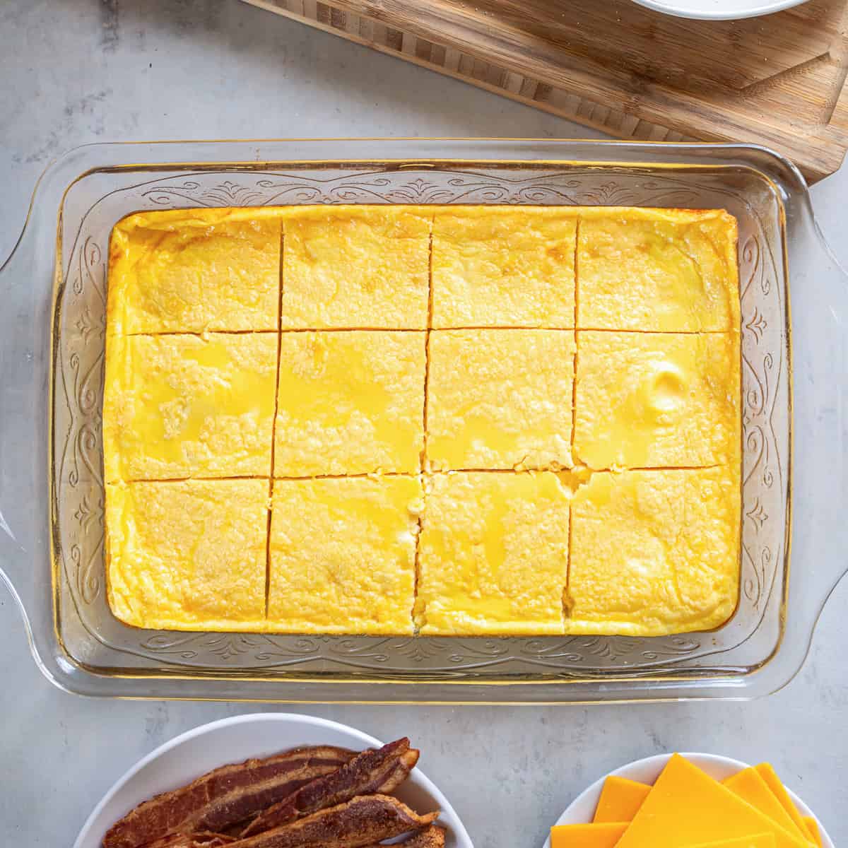 Baked egg mixture cut into 12 equal squares for assembling breakfast sandwiches.