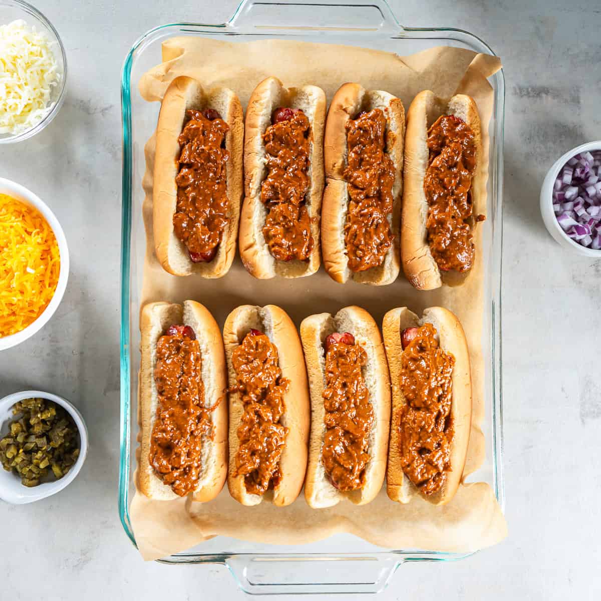 Hot dogs in buns topped evenly with canned chili.
