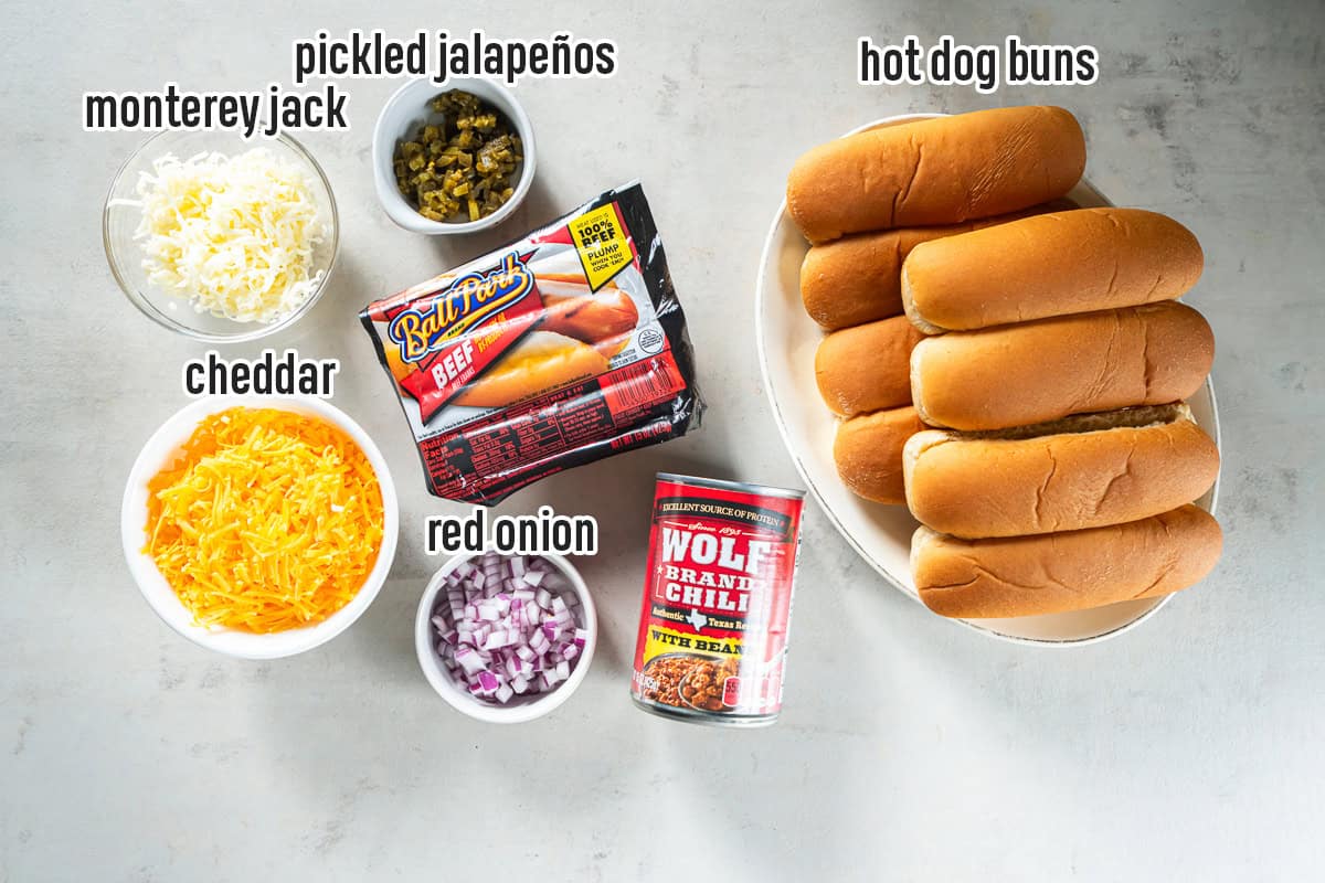 Hot dog buns, beef hot dogs, canned chili, shredded cheddar and Monterey Jack cheese, diced red onion, and pickled jalape&ntilde;os for baked chili dogs.