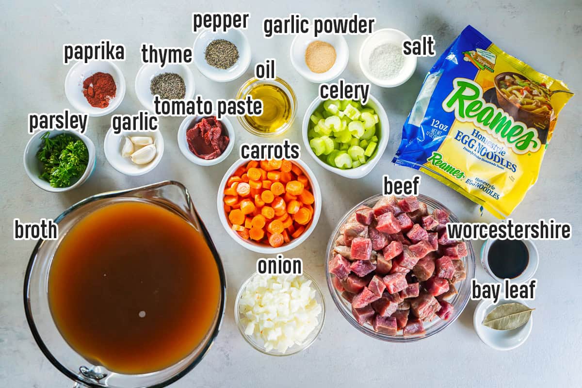 Beef noodle soup ingredients including beef, egg noodles, carrots, celery, onion, broth, tomato paste, garlic, herbs, and seasonings with text overlay.