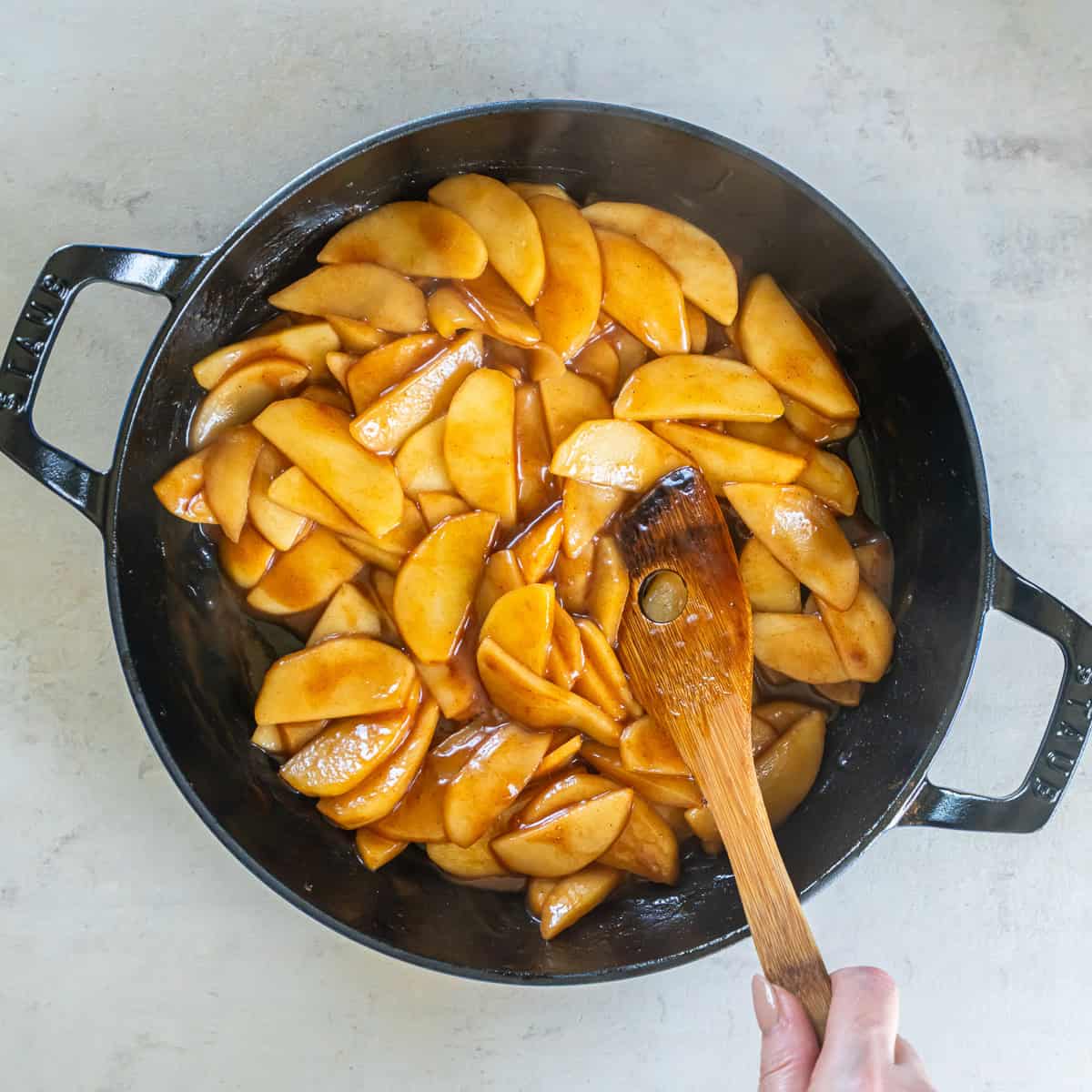 Finished cinnamon apples coated in a glossy cinnamon brown sugar sauce.
