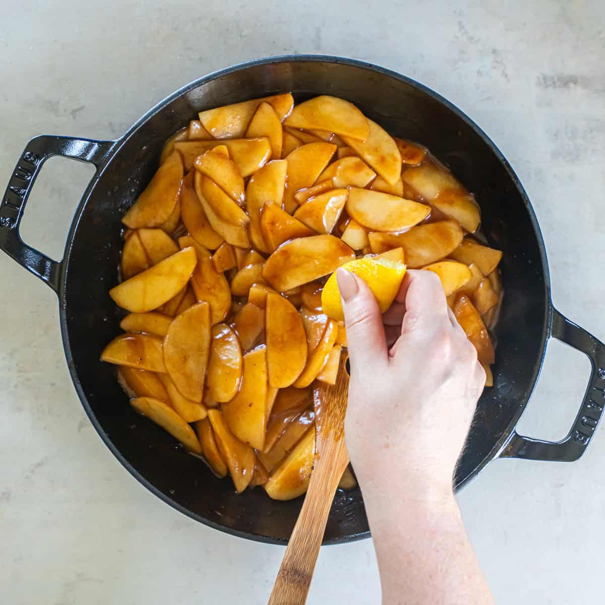 Fresh lemon juice being added to cooked cinnamon apples.