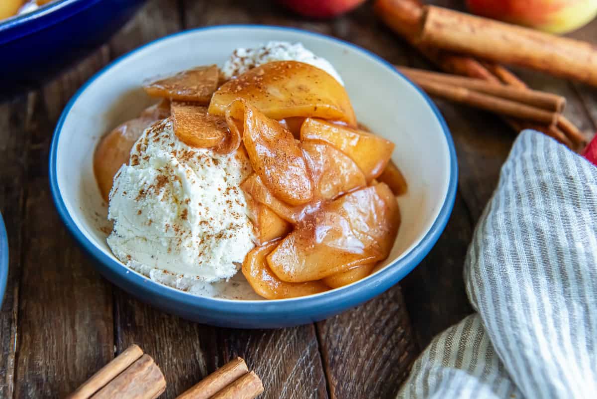 Cinnamon apples served warm over vanilla ice cream with a sprinkle of cinnamon.