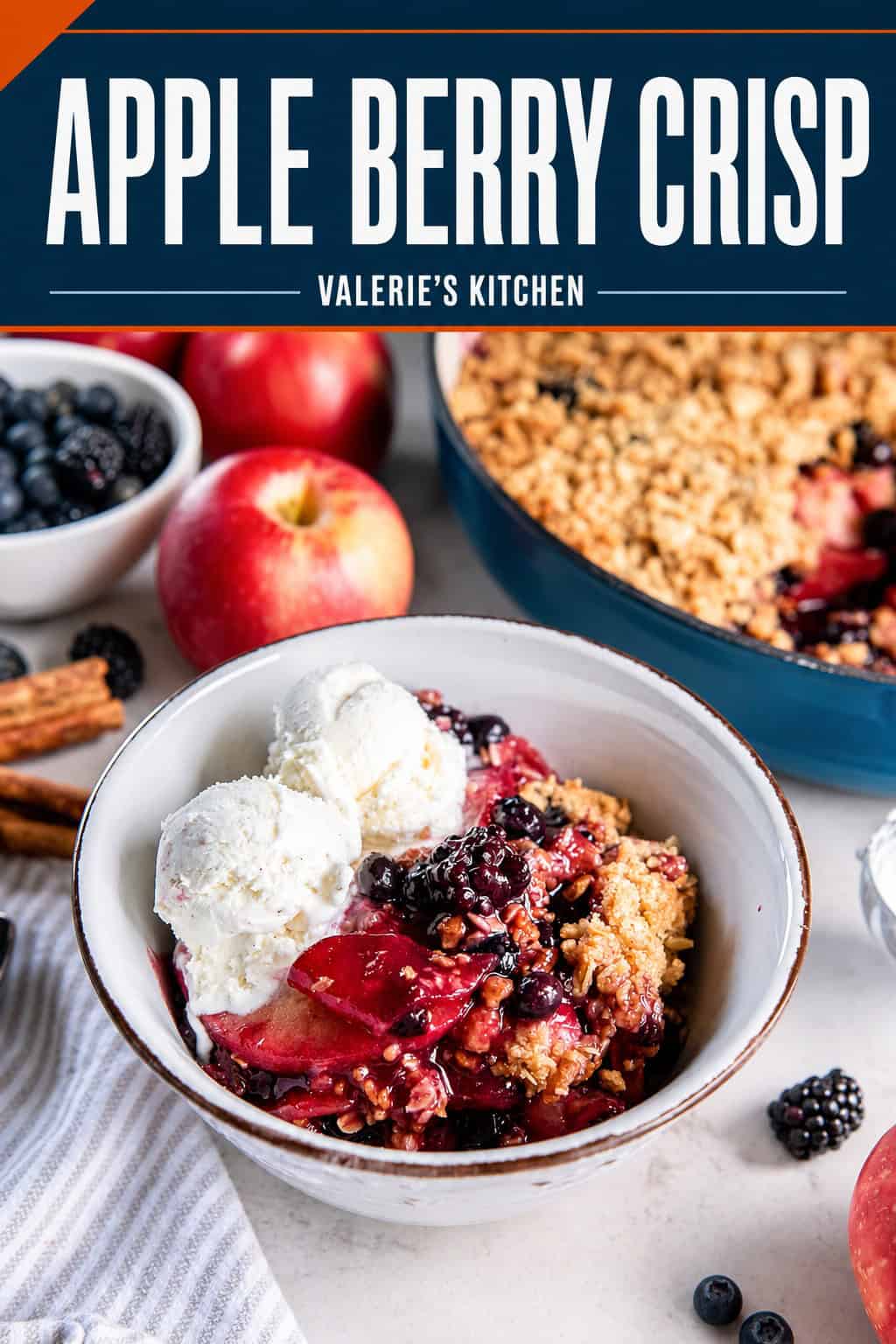 Apple Berry Crisp served warm in a bowl with two scoops of vanilla ice cream, with the baked crisp, apples, and berries in the background with bold title text overlay.