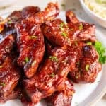 Slow Cooker Country Style Ribs coated in a sticky, caramelized BBQ sauce and garnished with parsley.
