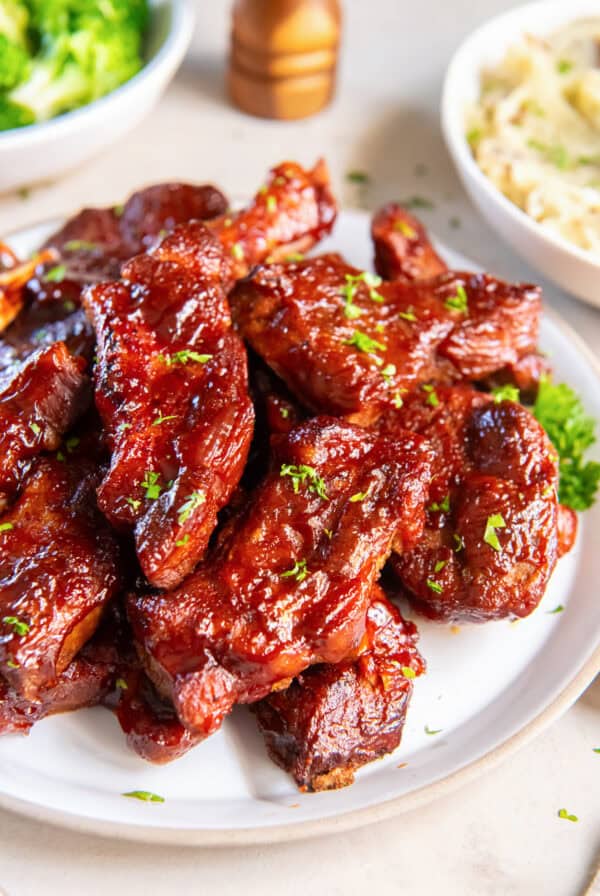 Slow Cooker Country Style Ribs coated in a sticky, caramelized BBQ sauce and garnished with parsley.