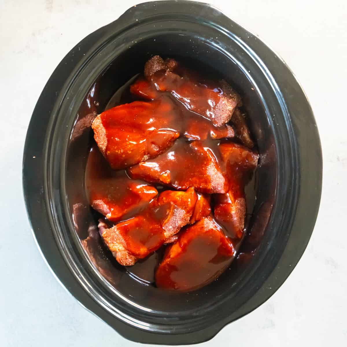 Add the seasoned ribs and pour the sauce over them.