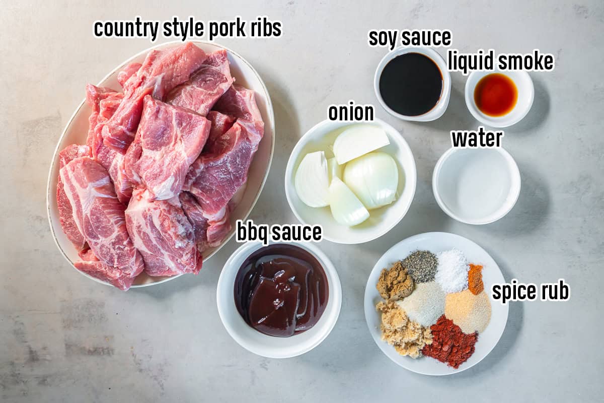 Ingredients for Slow Cooker Country Style Ribs, including country style pork ribs, onion, BBQ sauce, soy sauce, liquid smoke, water, and a smoky spice rub.