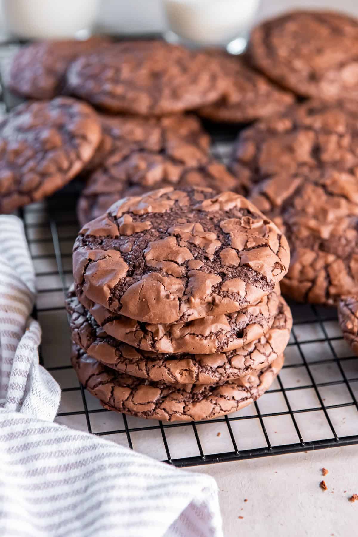 Stack of brownie mix cookies with shiny, crackly tops on a wire cooling rack.