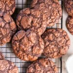 Brownie mix cookies with shiny, crackly tops arranged on a wire cooling rack.