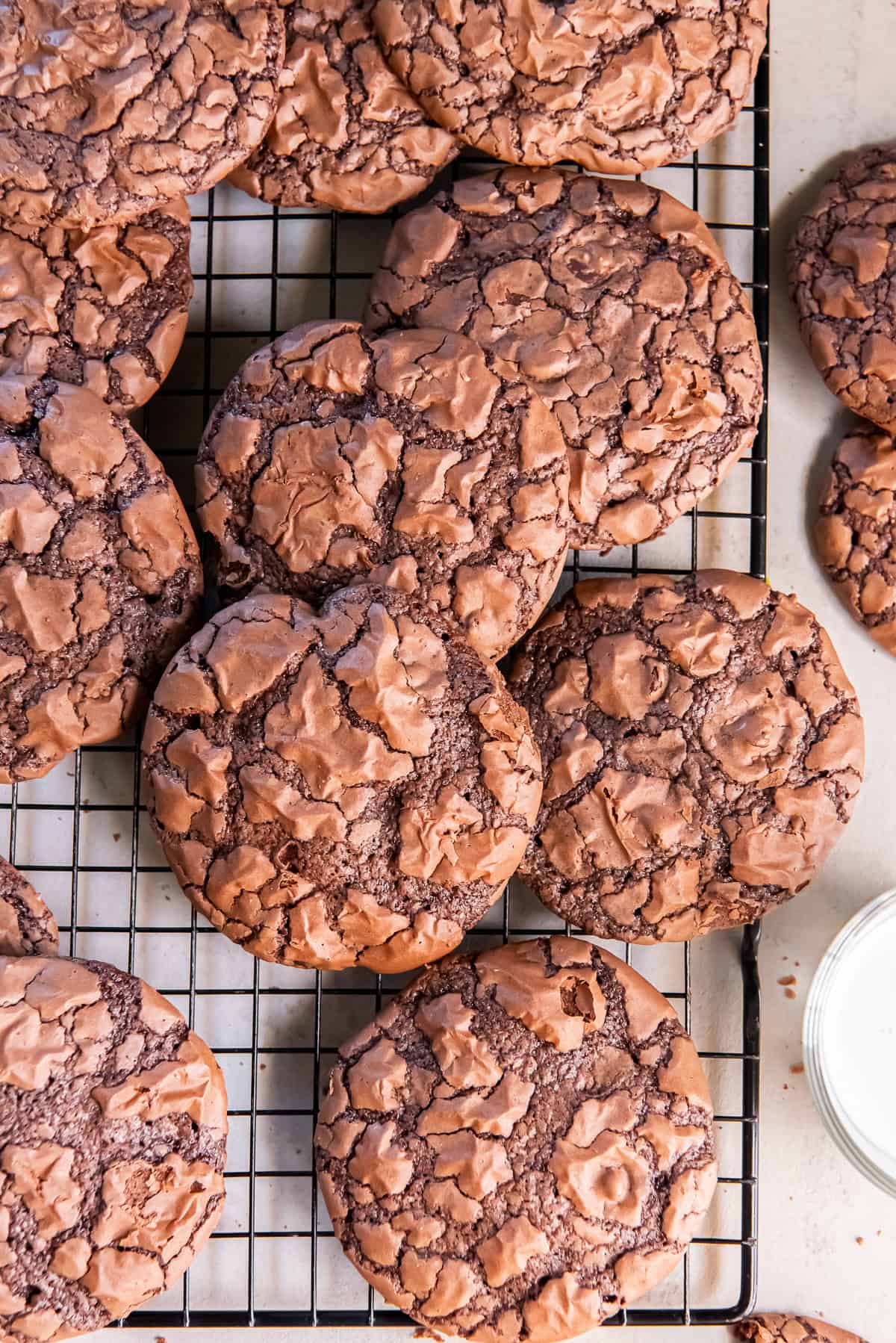 Brownie mix cookies with shiny, crackly tops arranged on a wire cooling rack.
