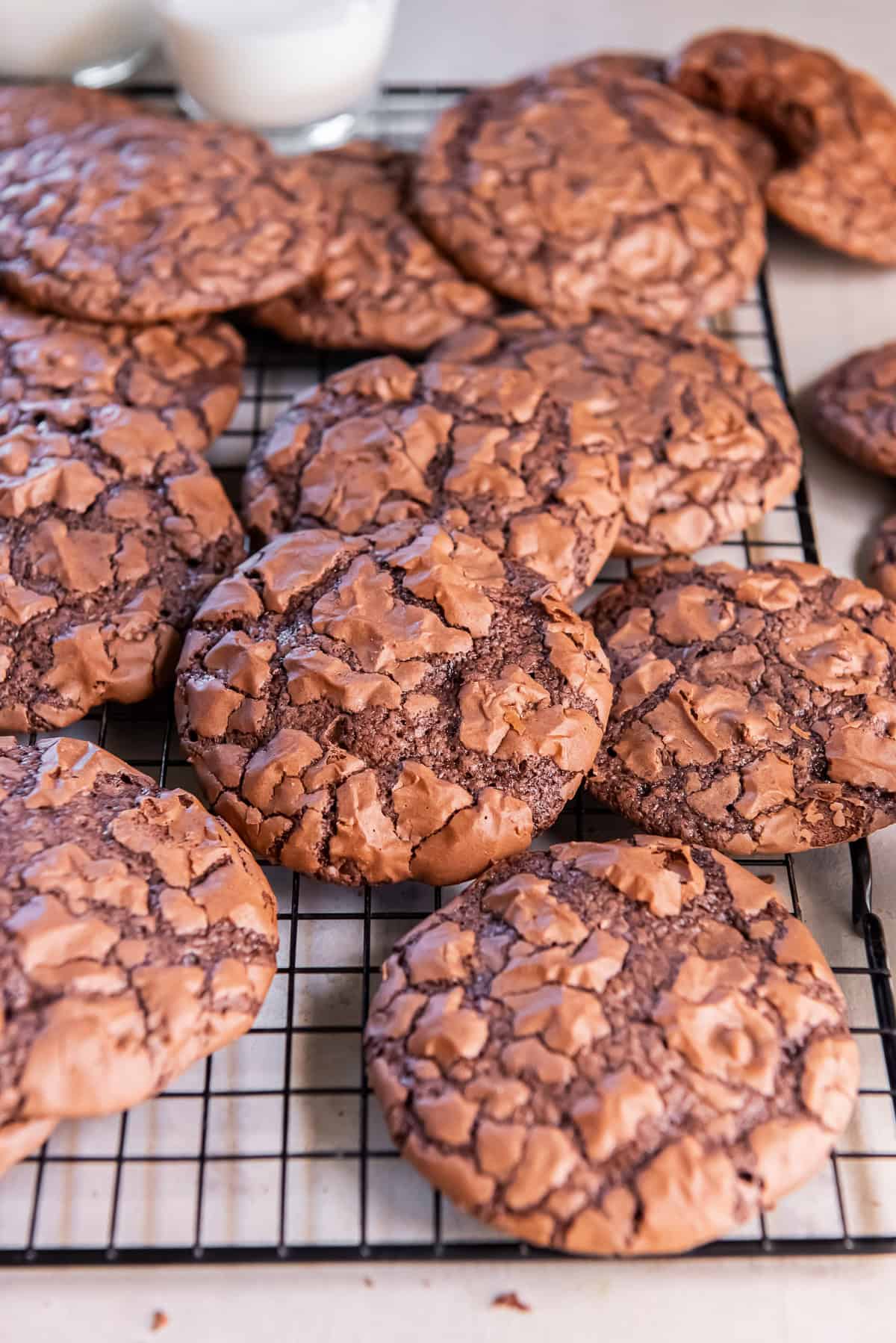 Brownie mix cookies with shiny, crackled tops arranged on a wire cooling rack.
