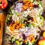 Roasted butternut squash salad with chicken, crisp apples, dried cranberries, sliced almonds, feta cheese, and red onion on a bed of mixed greens, served with maple Dijon vinaigrette.