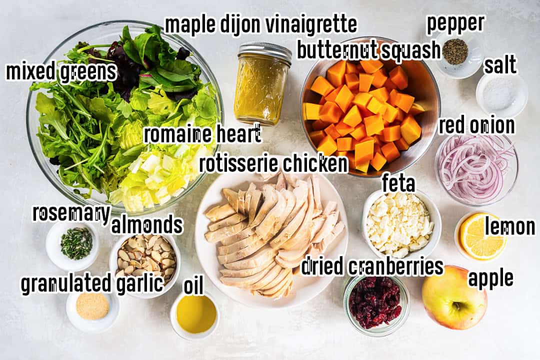 Ingredients for Butternut Squash Salad with Chicken, including cubed squash, rotisserie chicken, mixed greens, apples, cranberries, feta, almonds, and Maple Dijon Vinaigrette.