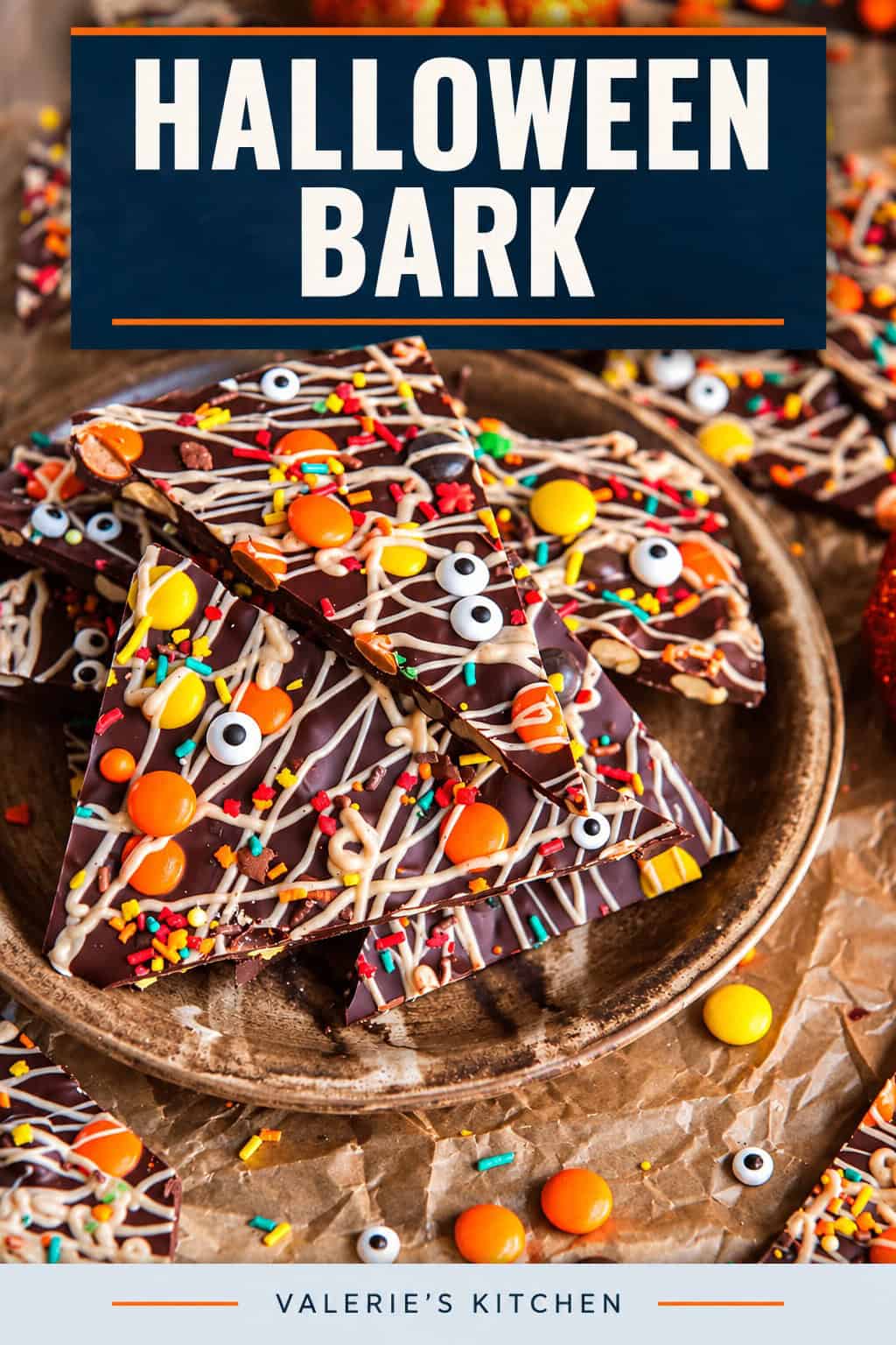 Halloween chocolate bark piled on a rustic plate, topped with white chocolate drizzle, Reese’s Pieces, colorful sprinkles, and candy eyeballs with bold title text overlay.