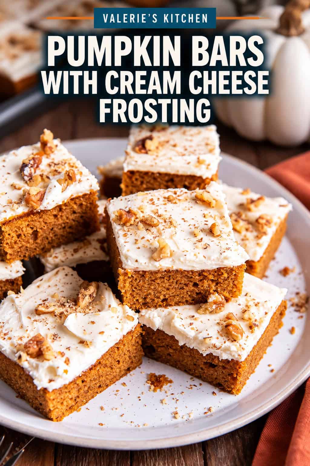 A tray of pumpkin bars topped with cream cheese frosting, cut into neat squares with bold title text overlay.