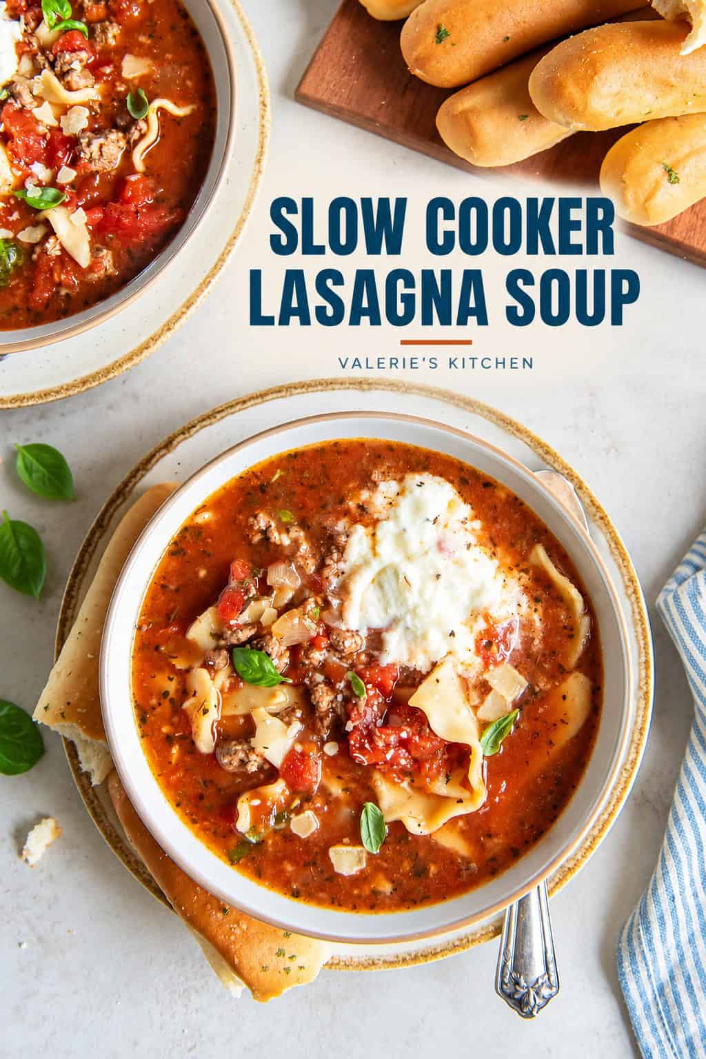Two bowls of lasagna soup next to breadsticks on a board with bold title text overlay.