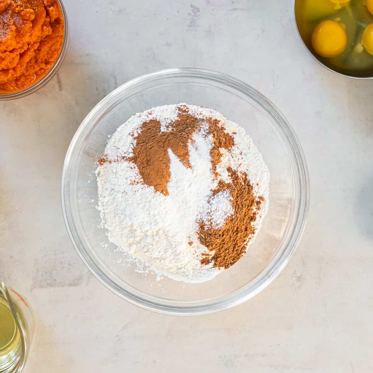 Flour, baking powder, baking soda, cinnamon, pumpkin pie spice, and salt in a mixing bowl.